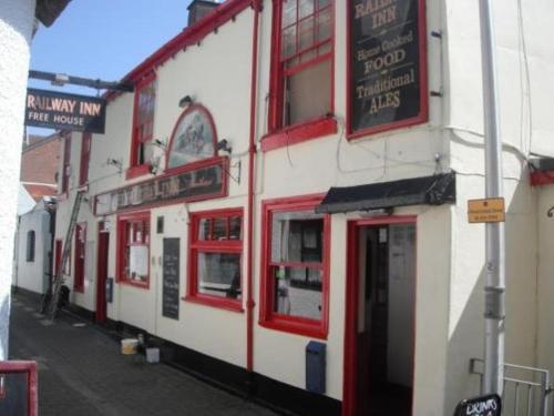 - un bâtiment rouge et blanc avec des fenêtres rouges sur une rue dans l'établissement The Railway Inn, à Dawlish