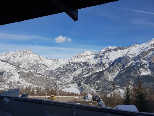 a view of a snowy mountain range with trucks at studio 4/5 couchages puy saint vincent 1600 in Puy-Saint-Vincent