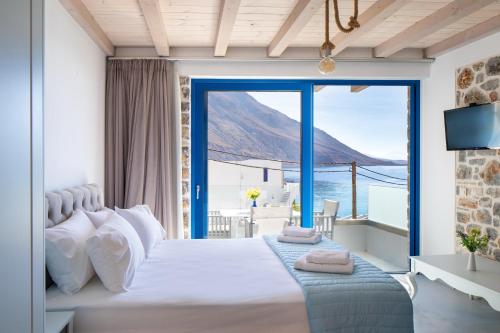 a bedroom with a large bed with a view of the ocean at Molos Apartments in Loutro