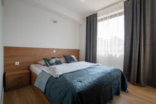 ein Schlafzimmer mit einem Bett und einem großen Fenster in der Unterkunft Aspen in Wisła