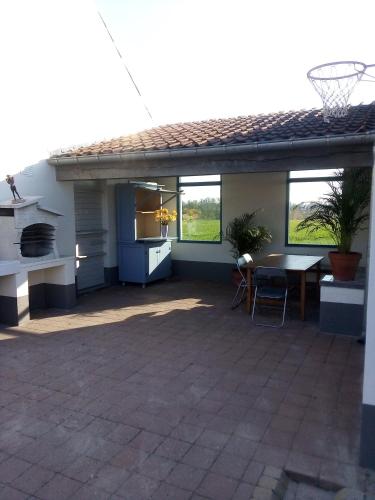 a patio with a table and a basketball hoop at Vakantiewoning De Wilg - rustig gelegen in Geraardsbergen