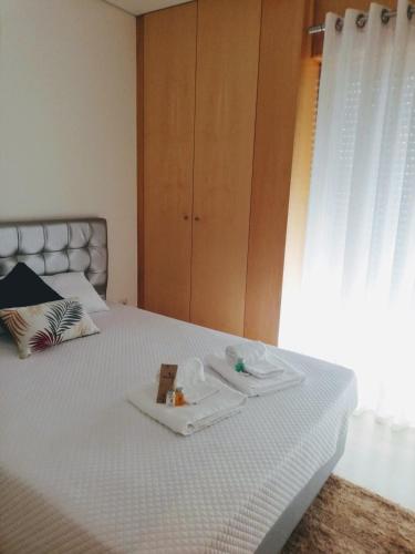 a bed with a tray of food on it at Apartamento Praia do Relógio in Figueira da Foz