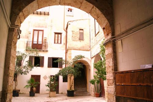 un arco en un antiguo edificio con macetas en BeeClaire Guest House en Palermo