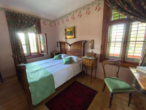 Schlafzimmer mit einem Bett, einem Stuhl und Fenstern in der Unterkunft Villa Ruska dača in Ljubljana