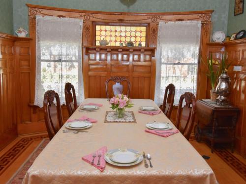 a dining room with a table with flowers on it at The Scofield House B&B in Sturgeon Bay