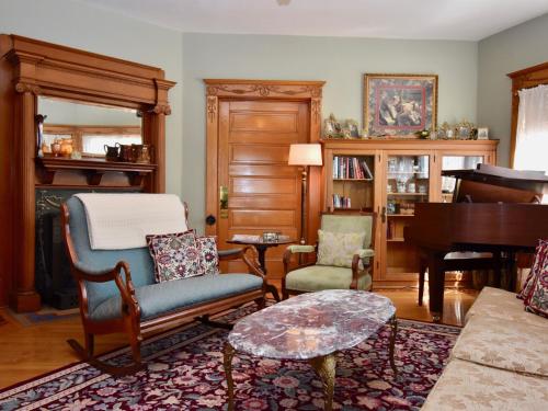 a living room filled with furniture and a piano at The Scofield House B&B in Sturgeon Bay