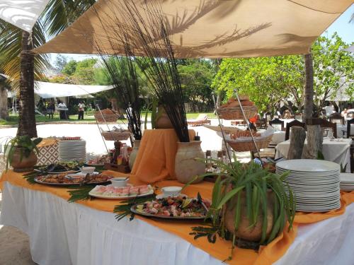 einen Tisch mit Lebensmittelplatten und Pflanzen darauf in der Unterkunft Kilili Baharini Resort & Spa in Malindi