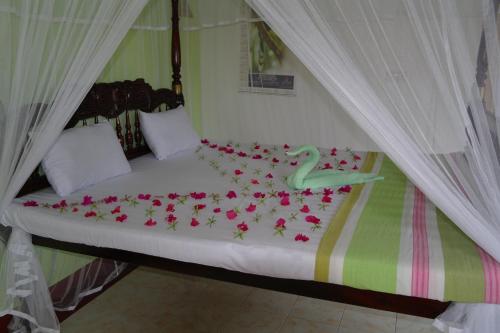 łóżko z różowymi kwiatami w obiekcie Castle Bay Resort w mieście Weligama