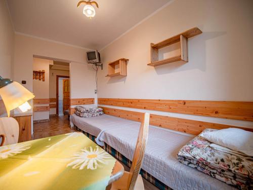 a room with two beds and a table at Dom Wczasowy Stanislawa in Biały Dunajec