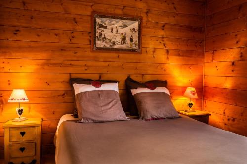Gite Balnéo La Pomme de Pin في سيكْسْت: غرفة نوم بسرير في غرفة خشبية