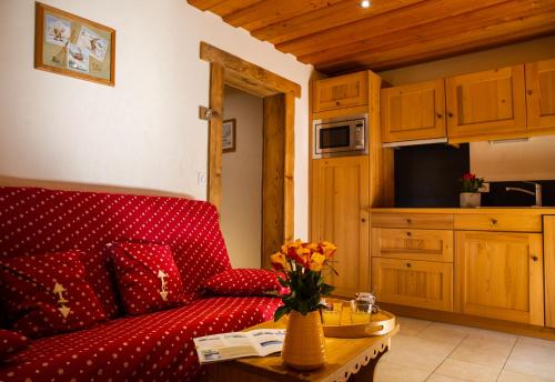 un salon avec un canapé rouge et une table dans l'établissement Gite Balnéo La Pomme de Pin, à Sixt-Fer-à-Cheval