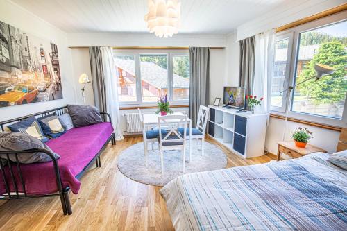 a living room with a purple couch and a table at Le Clavan - Studio à Crans-Montana (2-4 personnes) in Crans-Montana