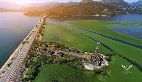 an island in the middle of a body of water at Green Field Apartments in Virpazar