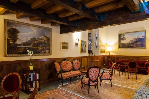 a room with chairs and a table and a painting at Hotel Foresteria Baglio Della Luna in San Leone