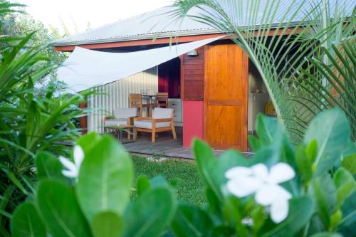 uma pequena casa com uma mesa e cadeiras num jardim em Shambala Lodge em Le Moule