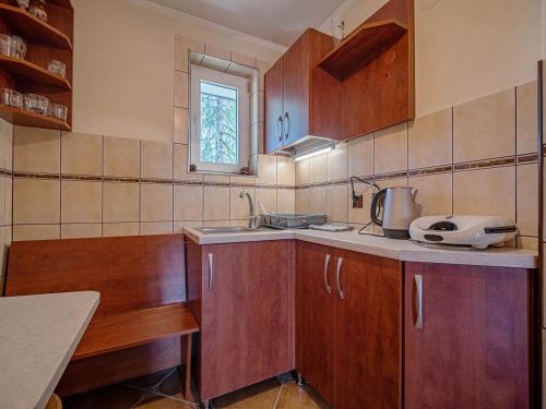 a kitchen with wooden cabinets and a sink at Dom Wczasowy Stanislawa in Biały Dunajec