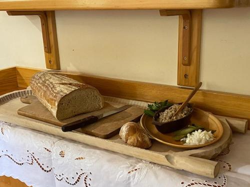 a tray with a loaf of bread and a plate of food at Dom Wczasowy Stanislawa in Biały Dunajec