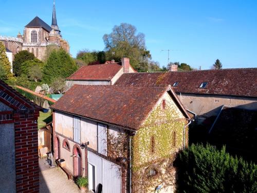 un vieux bâtiment avec du lierre dans un village dans l'établissement La Maison d'hotes de Toucy, à Toucy
