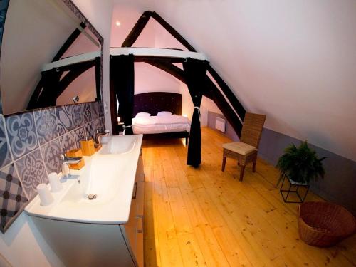 a bathroom with a sink and a bed in a room at La Maison d'hotes de Toucy in Toucy