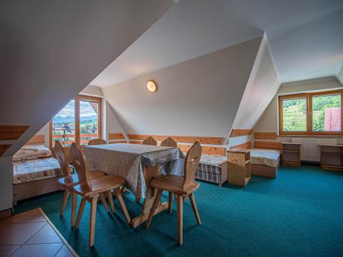 a room with a table and chairs and a bed at Dom Wczasowy Stanislawa in Biały Dunajec