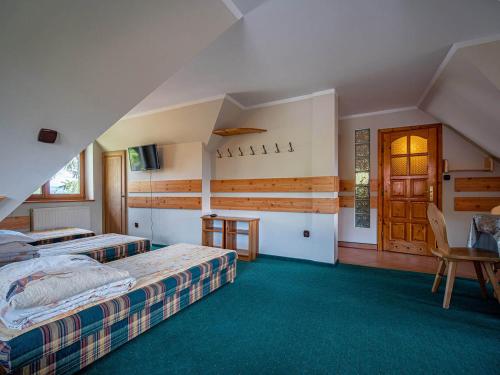 a hotel room with two beds and a table at Dom Wczasowy Stanislawa in Biały Dunajec