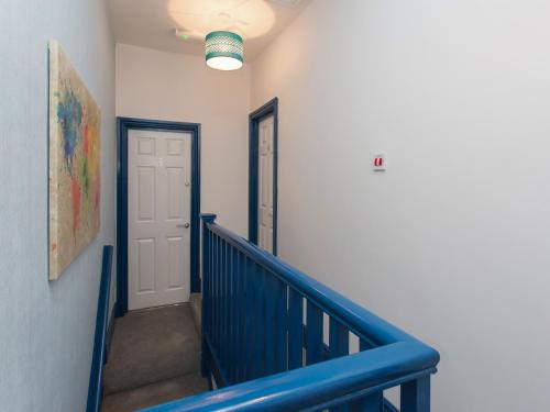 a hallway with a blue railing and a door at Townhouse PLUS @ Westminster Street Crewe in Crewe