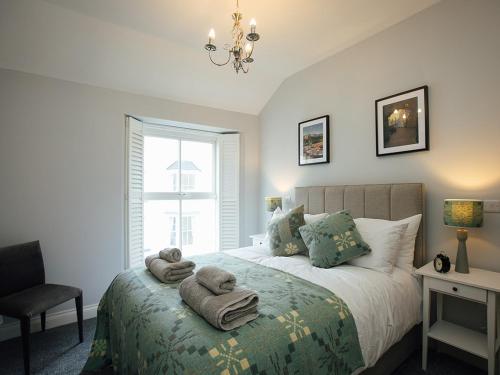 a bedroom with a bed with towels on it at The Townhouse in Tenby