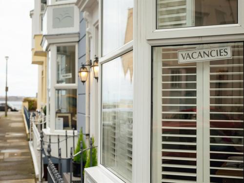 ein Lagerfenster mit einem Schild an der Seite eines Gebäudes in der Unterkunft The Townhouse in Tenby