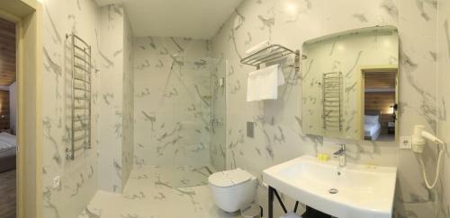 a white bathroom with a sink and a mirror at Family Home in Bukovel