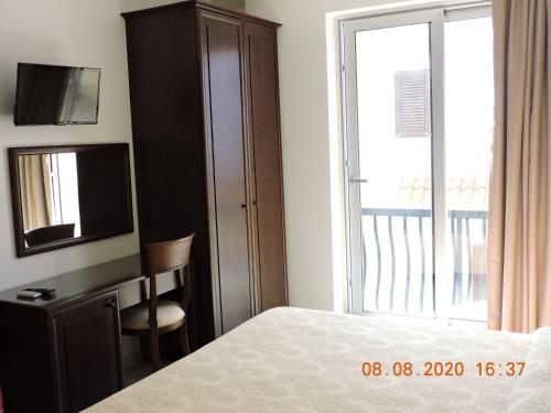 a bedroom with a bed and a dresser with a television at B&B Aquila Reale in Portopalo