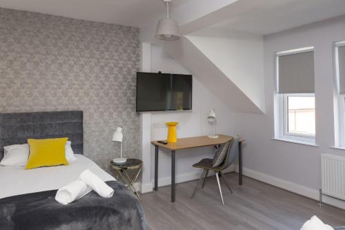 a bedroom with a bed and a desk and a tv at Titanic Guest 4 Star Boutique- Tourism NI certified- Free parking in Belfast