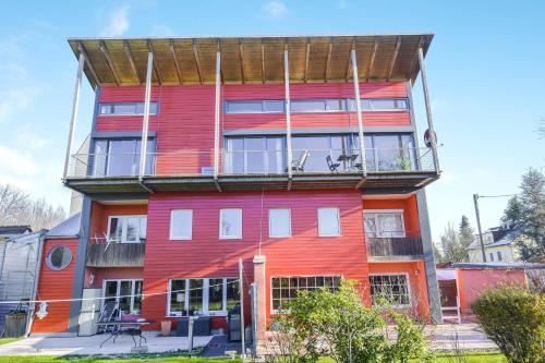 a red building with a balcony on top of it at Muc City de Lux 120 qm in Munich