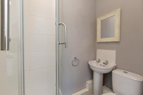 a bathroom with a shower and a toilet and a sink at Townhouse @ Electricity Street Crewe in Crewe