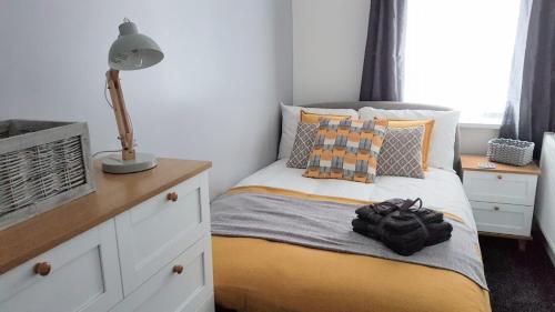 a bedroom with a bed with a lamp on it at Townhouse @ Birches Head Road Stoke in Stoke on Trent