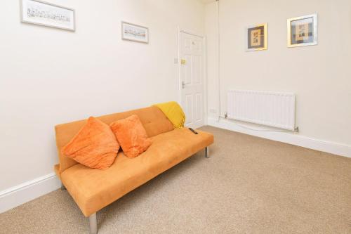 a couch in a living room with orange and yellow pillows at Townhouse @ Earle Street Crewe in Crewe