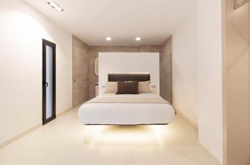 a bedroom with a white bed in a room at Olivera in Búger