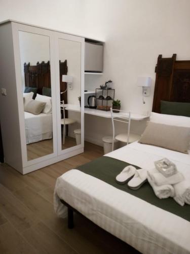 a bedroom with a bed and a mirror with towels on it at Vittorio Veneto Private SPA in Sulmona