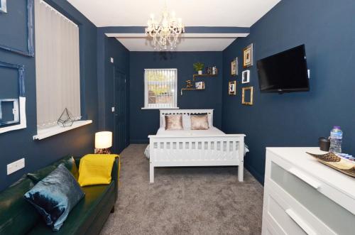 Habitación azul con cama y sofá en Townhouse PLUS @ 301 West Street Crewe, en Crewe