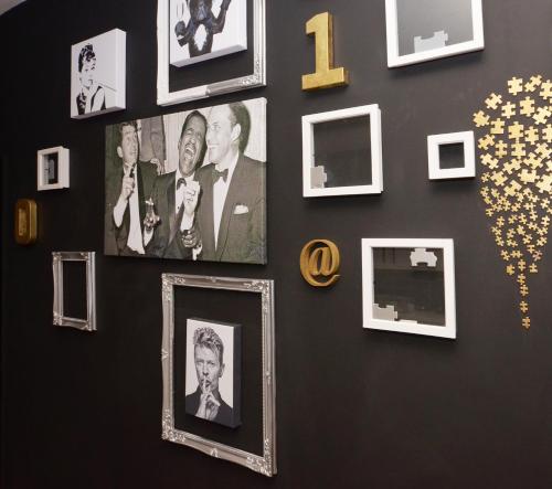 a wall with pictures offamousfamous people and gold stars at Townhouse PLUS @ 301 West Street Crewe in Crewe
