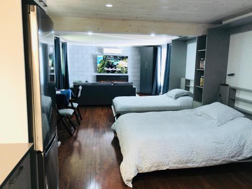 um quarto com 2 camas e uma sala de estar em Loft des Suites North Hatley em North Hatley