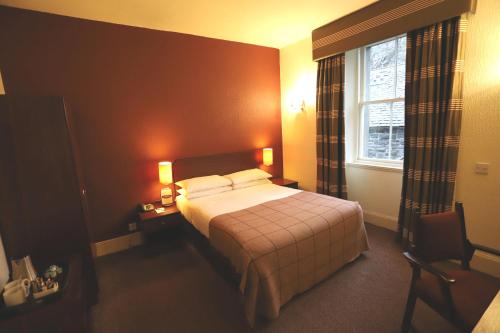 a hotel room with a bed and a desk at Ben Wyvis Hotel in Strathpeffer