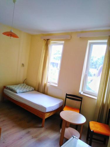 a small bedroom with a bed and two windows at Éden Fonyód in Fonyód