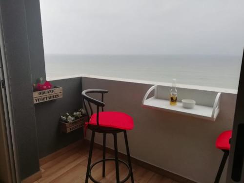 a bar with two stools and a bottle of beer at EuVe Ocean View Flat in Lima in Lima