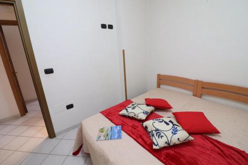 a bedroom with a bed with red and white pillows at Casa vacanze Arianna in centro in Otranto