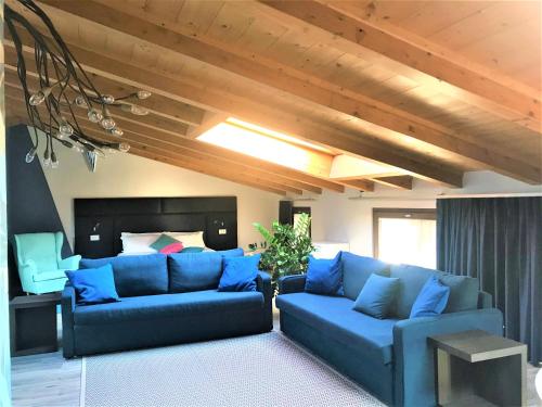 a living room with blue couches and wooden ceilings at Residenza del Borgo in Bergamo