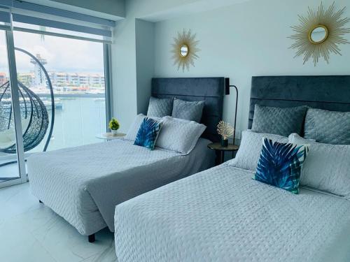 a bedroom with two beds and a balcony at Nautico departamento Marina Vallarta in Puerto Vallarta