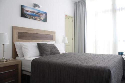 Un dormitorio con una cama grande y una ventana en The Cathedral Rooms, en Málaga