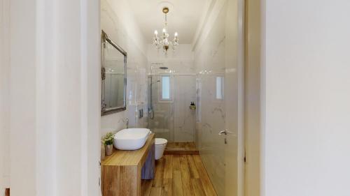 ein Badezimmer mit einer weißen Badewanne und einem Waschbecken in der Unterkunft Penthouse of light @ Koukaki in Athen