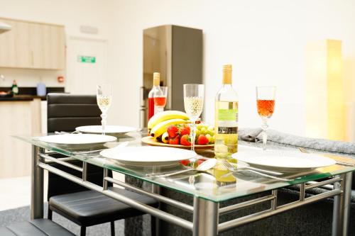 a table with glasses of wine and fruit on it at Serviced Property Plymouth in Plymouth