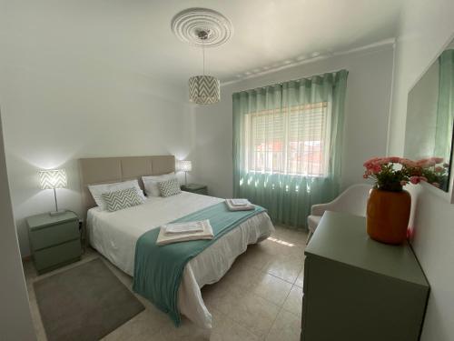 ein Schlafzimmer mit einem Bett, einem Stuhl und einem Fenster in der Unterkunft Casa do Mar in Peniche